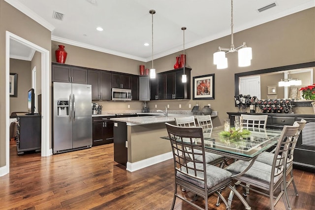 kitchen with ornamental molding, stainless steel appliances, dark wood-type flooring, an inviting chandelier, and hanging light fixtures