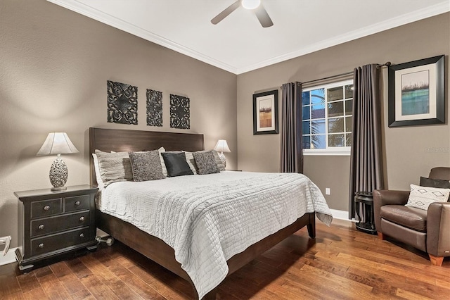 bedroom featuring dark hardwood / wood-style flooring, ceiling fan, and crown molding