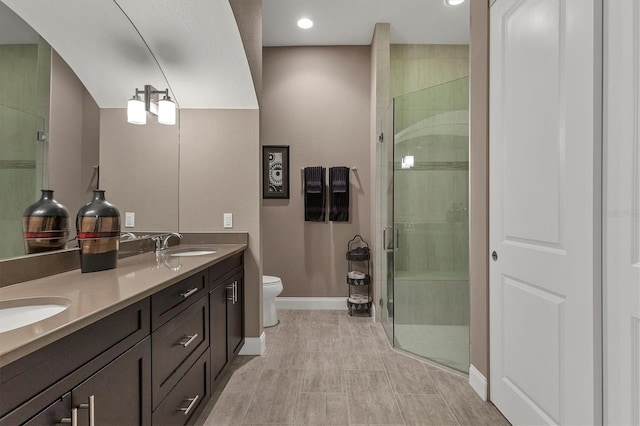 bathroom with vanity, toilet, and a shower with shower door