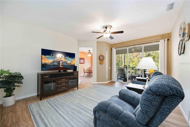 living room featuring ceiling fan and light hardwood / wood-style flooring