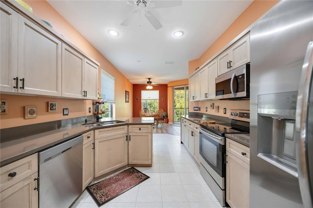 kitchen with sink, ceiling fan, appliances with stainless steel finishes, light tile patterned flooring, and kitchen peninsula