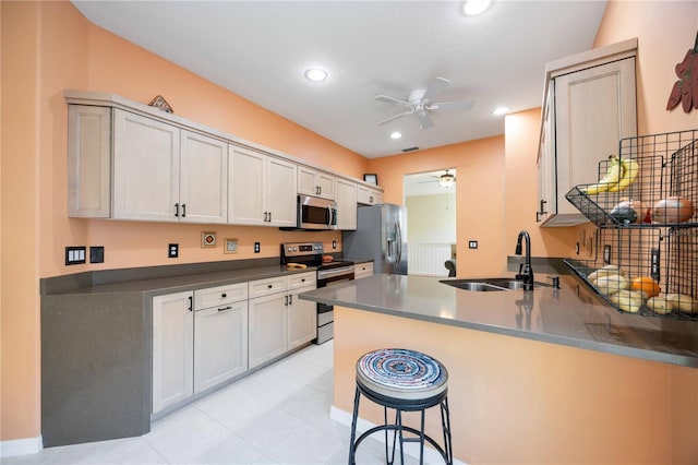 kitchen featuring white cabinetry, sink, stainless steel appliances, kitchen peninsula, and a breakfast bar