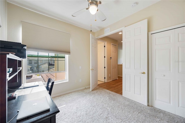 carpeted home office with ceiling fan