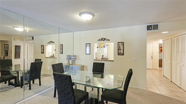 tiled dining room with a textured ceiling