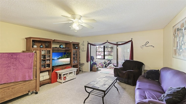 living room with ceiling fan, light colored carpet, and a textured ceiling