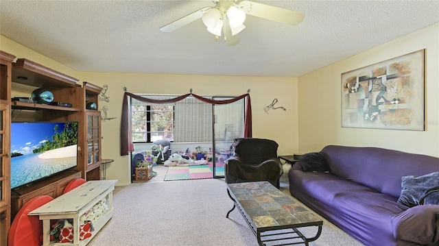 living room featuring carpet flooring, ceiling fan, and a textured ceiling