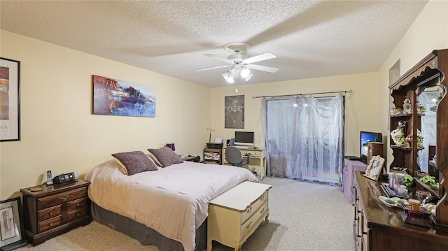 carpeted bedroom featuring ceiling fan and a textured ceiling