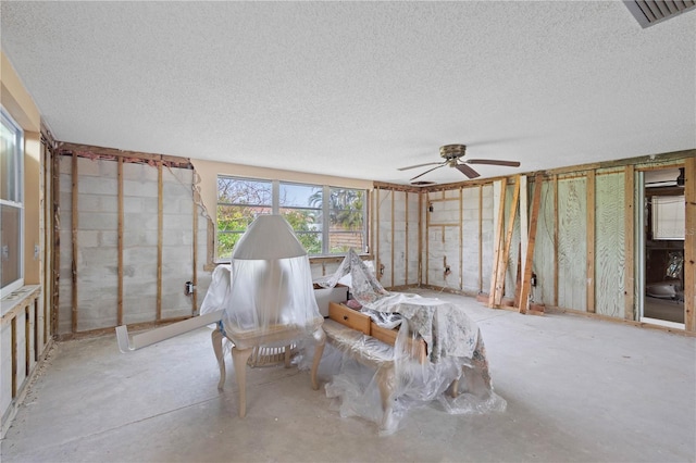 miscellaneous room with ceiling fan and a textured ceiling