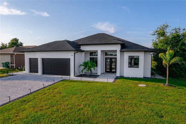 prairie-style home with french doors, a front yard, and a garage