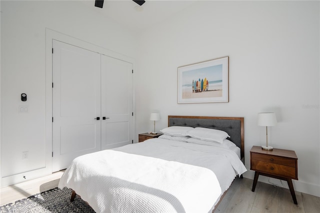 bedroom with light hardwood / wood-style flooring, ceiling fan, and a closet