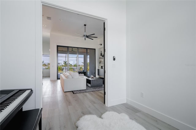 living room with light hardwood / wood-style floors and ceiling fan