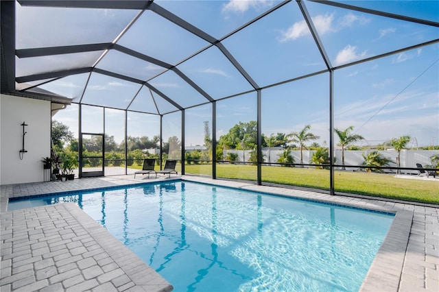 view of pool featuring a patio area, a lawn, and glass enclosure