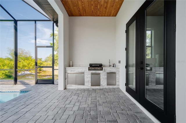 view of patio with a grill, a lanai, and exterior kitchen