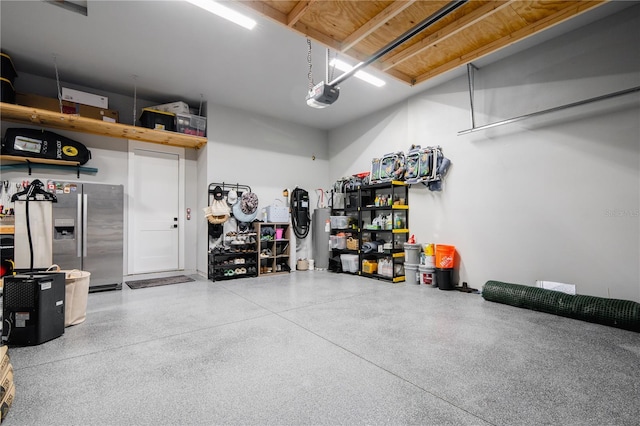 garage with stainless steel refrigerator with ice dispenser and a garage door opener