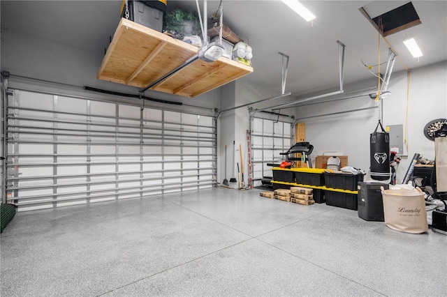 garage with a garage door opener and electric panel