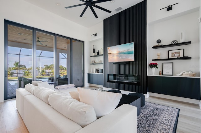 living room with ceiling fan and light hardwood / wood-style floors