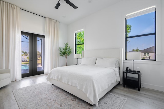 bedroom featuring access to outside, light hardwood / wood-style floors, french doors, and ceiling fan