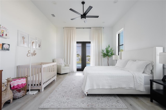 bedroom featuring ceiling fan, access to outside, light wood-type flooring, and french doors