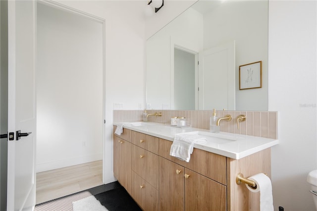 bathroom featuring vanity, decorative backsplash, and wood-type flooring