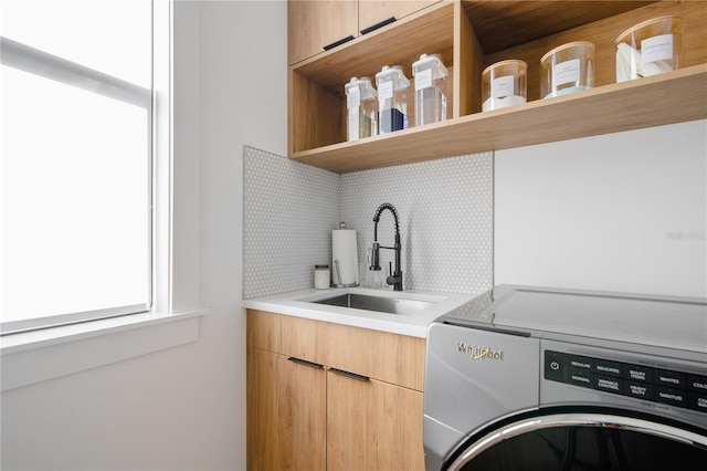 laundry area featuring washer / clothes dryer, sink, and cabinets