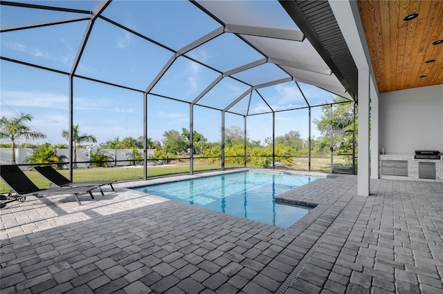 view of swimming pool featuring a patio, glass enclosure, and a lawn