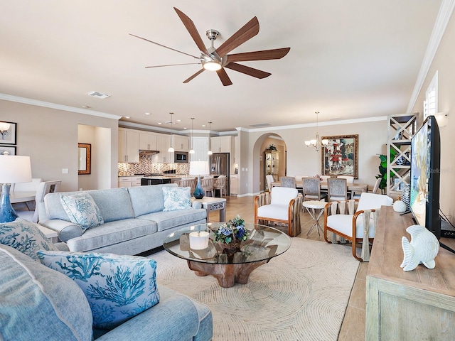 tiled living room featuring ceiling fan with notable chandelier and crown molding