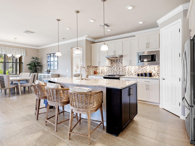 kitchen with white cabinets, pendant lighting, sink, and appliances with stainless steel finishes