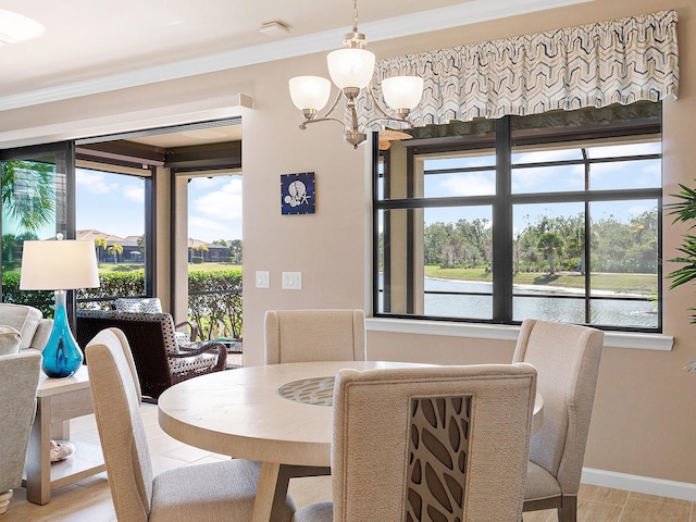 dining area with a water view, ornamental molding, and an inviting chandelier