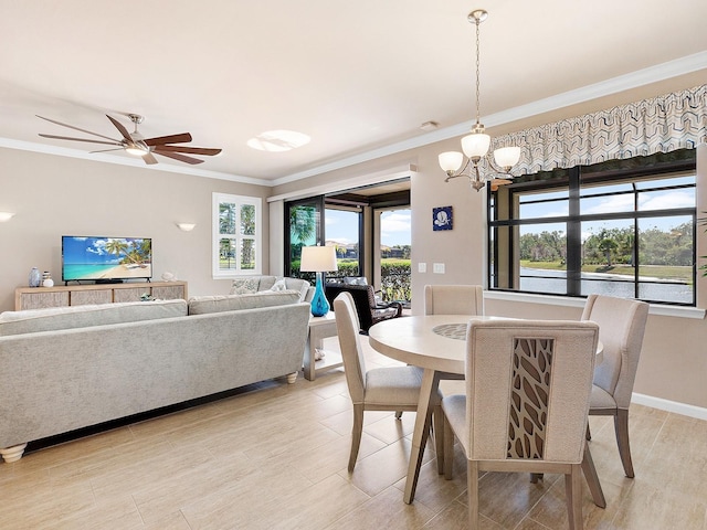 dining space with plenty of natural light, crown molding, and ceiling fan with notable chandelier