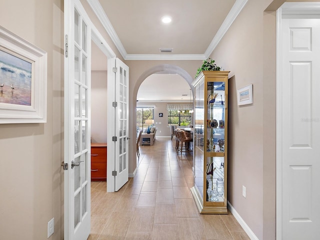 hallway featuring crown molding, french doors, and light tile patterned floors