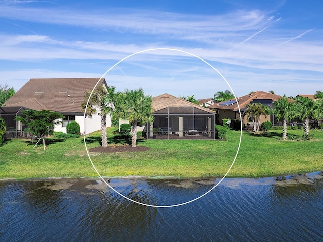 rear view of house with glass enclosure, a yard, and a water view