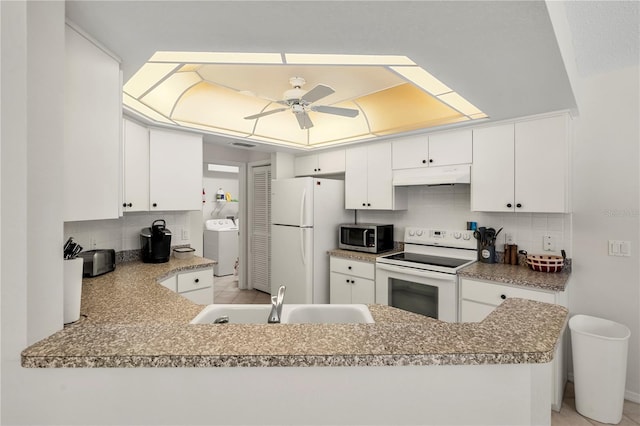 kitchen featuring kitchen peninsula, decorative backsplash, white appliances, sink, and white cabinetry