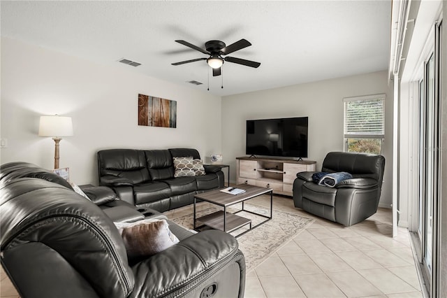 tiled living room with ceiling fan and a textured ceiling