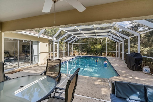 view of pool with a lanai, ceiling fan, a grill, and a patio area