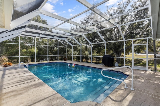 view of swimming pool with glass enclosure, a patio area, and area for grilling