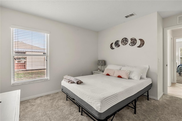 carpeted bedroom featuring multiple windows