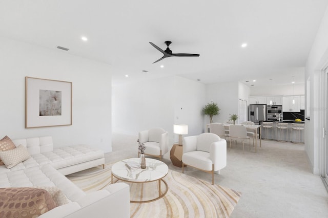 living room featuring light colored carpet and ceiling fan