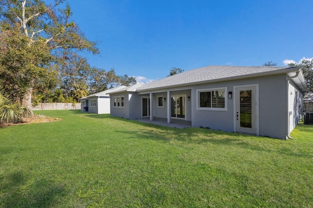 back of property with a lawn and central AC unit