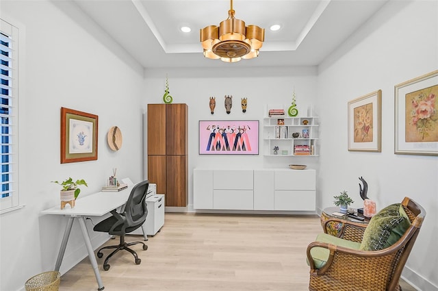 office with a chandelier, a tray ceiling, and light hardwood / wood-style floors