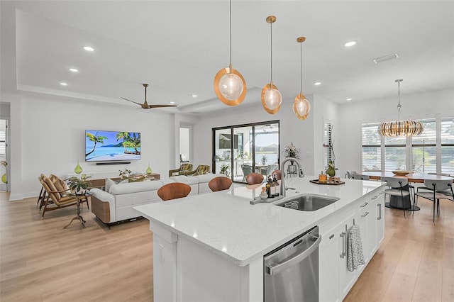 kitchen featuring dishwasher, sink, hanging light fixtures, an island with sink, and white cabinetry