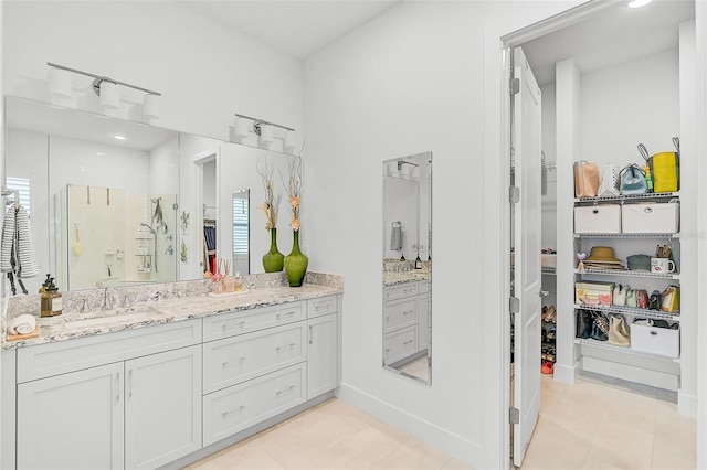 bathroom with tile patterned floors, vanity, and a shower with door