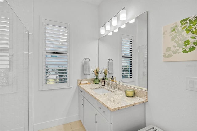 bathroom with tile patterned flooring, vanity, and a healthy amount of sunlight