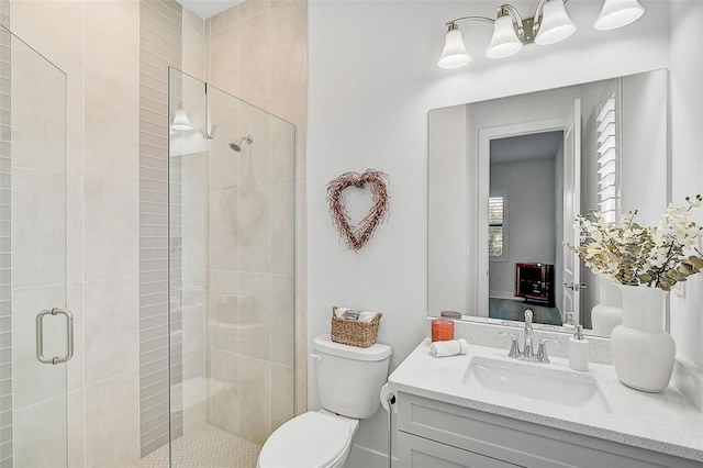 bathroom featuring vanity, toilet, and a shower with shower door