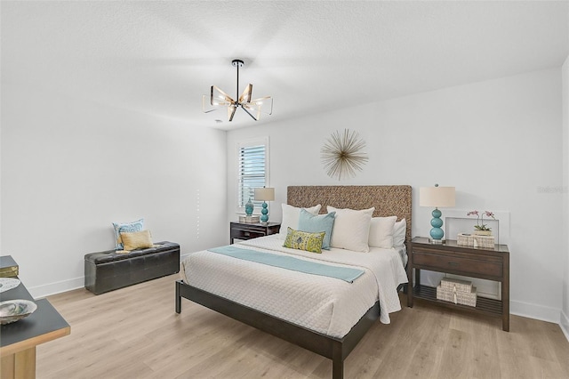 bedroom with a notable chandelier and light wood-type flooring