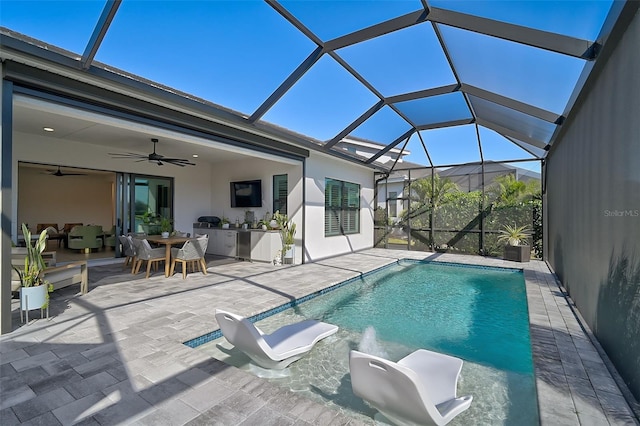 view of swimming pool featuring ceiling fan, a patio area, and glass enclosure