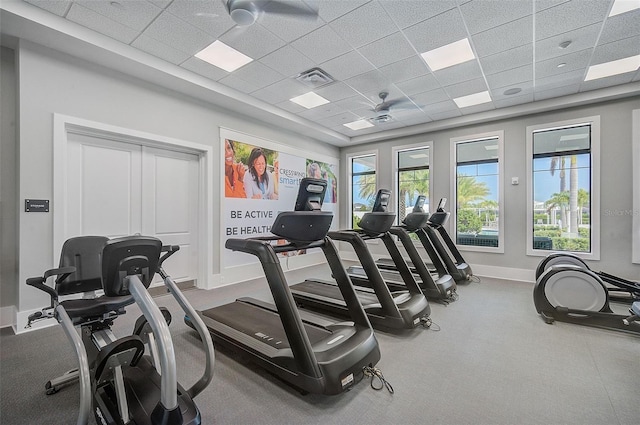 workout area with a paneled ceiling and ceiling fan