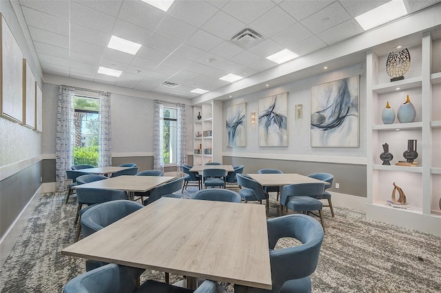 dining area featuring built in shelves and a drop ceiling