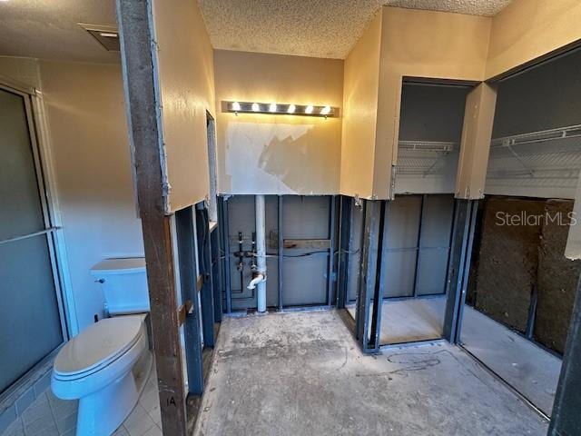 bathroom featuring a textured ceiling and toilet