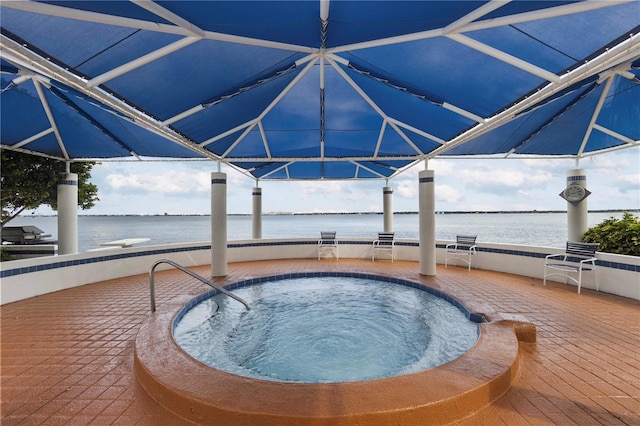 view of swimming pool featuring a jacuzzi and a water view