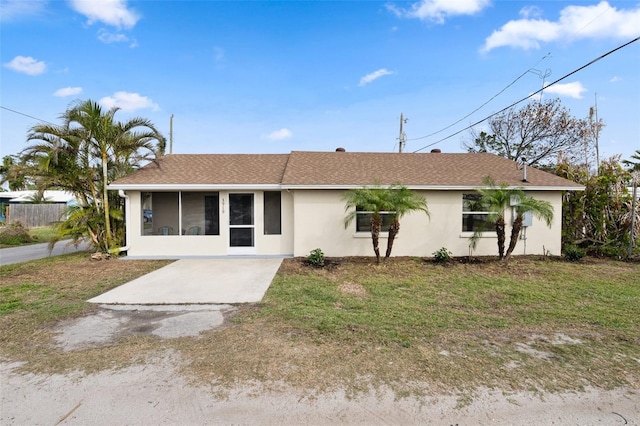 ranch-style home with a front lawn and a sunroom